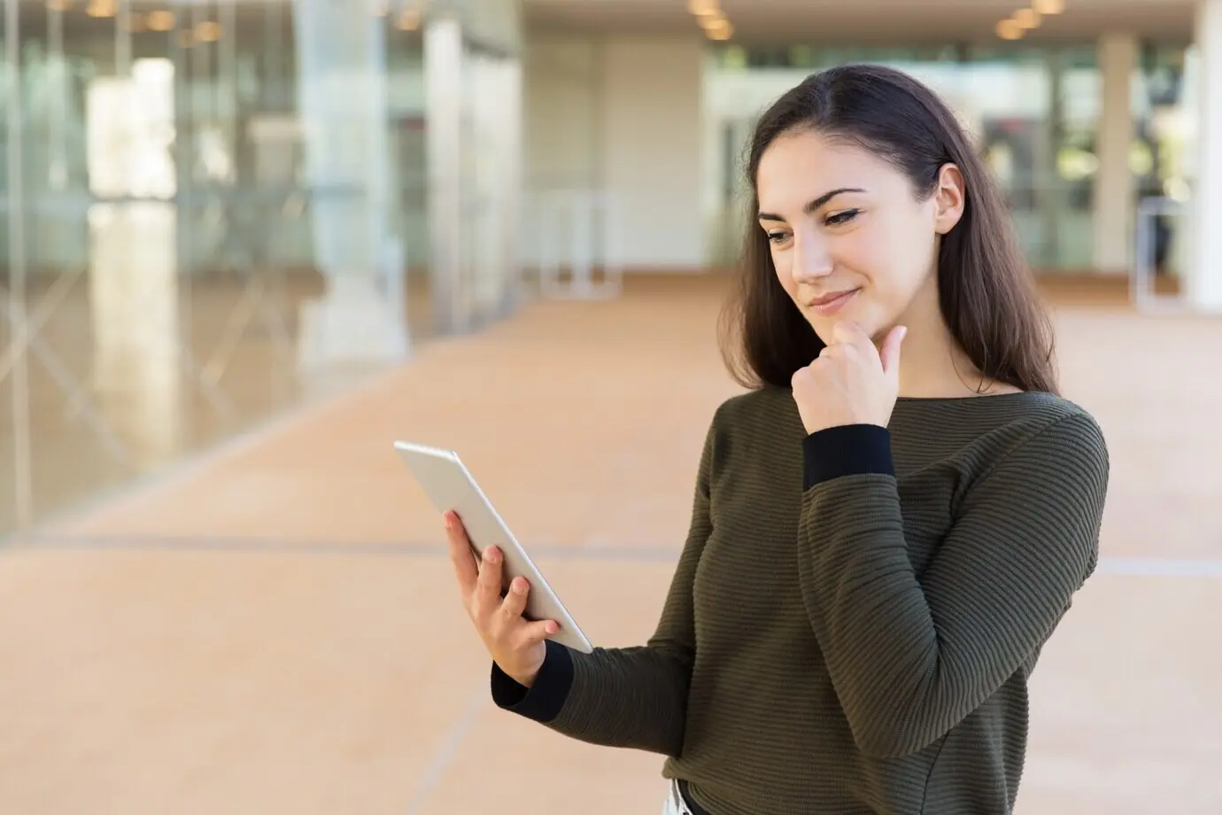Positiv gestimmte, nachdenkliche Kundin liest eine Nachricht.